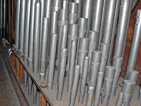 La tuyauterie du grand-orgue.Le
                    malheureux Principal 4' (dont les entailles d'accord ont été ressoudées), est au
                    premier plan.Plus le Bourdon 8', et, au fond, le Principal 8', dont les
                    entailles ont été préservées.