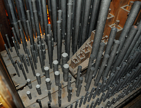 La tuyauterie du grand-orgue.
Elle est remarquablement bien conservée et entretenue.
Partant d'en bas à droite (passerelle d'accord) vers le haut à gauche (façade) :
la Mixture à 3 rangs (3 petits tuyaux par note), le Principal 4',
le gros Bourdon 8' (10 tuyaux sont métalliques - il y en a 10 autres de l'autre côté -, le reste est en bois),
la Dulciane 8', la Flûte 4' (pas d'origine, mais dont certains tuyaux sont anciens),
le Principal 8'.