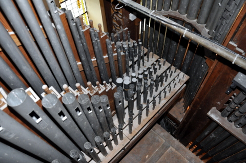 Une vue (plutôt vertigineuse) sur la tuyauterie du grand-orgue.
En haut, le revers de la tourelle latérale droite.
Tout en bas, le haut de la boîte expressive du récit.
Le sommier, diatonique (c'est celui de droite), est orthogonal à la façade.
Il porte 28 tuyaux de chaque jeu ; les autres sont de l'autre côté (56 en tout).
Depuis en bas à droite (accès), et vers le haut (côté de l'orgue) :
la Doublette, le Prestant, le Bourdon 8' (avec les basses en bois),
puis la fameuse Spillfloete (métallique et légèrement conique),
viennent ensuite le Bourdon 16', et la partie "sur le vent" de la Montre 8'.
