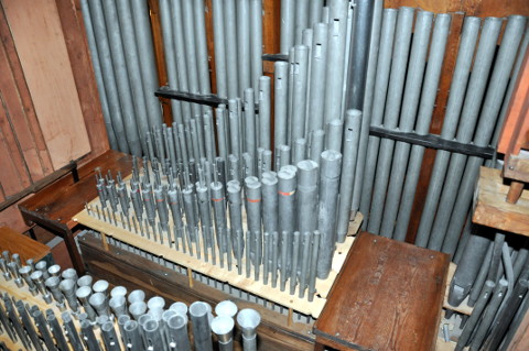 La partie avant des aigus du grand-orgue et positif.
Le revers de la façade est visible au fond. Le récit est à gauche.
Le sommier "avant", au centre de l'image, porte les 31 dessus (cis'-g''') des jeux suivants :
(depuis la façade vers le fond de l'orgue - donc ici de haut en bas)
le Principal 16', la Montre 8', le Principal 4',
le Bourdon 16' (20 - c''-g''' à cheminées) et l'Octavin.
Plus bas, il y a une passerelle, puis le sommier "arrière"
dont on voit quelques hauts de tuyaux dans le coin inférieur gauche.