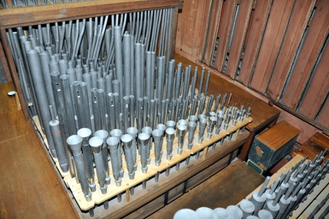 Le sommier "arrière" du grand-orgue et positif (vu de l'avant).
La vue est pivotée, par rapport à la précédente, de 90° vers la gauche.
On retrouve le Bourdon 16' dans le coin inférieur droit.
Depuis la passerelle vers le fond de l'orgue
donc d'en bas à droite vers en haut à gauche :
la Clarinette (Pos.), la Doublette (Pos.), la Gambe (Pos.),
le Bourdon 8', la Flûte 8', le Salicional 8',
la Flûte octaviante 4', le Gemshorn 8' (Pos.),
la Quinte-flûte 2'2/3 (Pos.), puis les postages du Cornet,
masquant le reste.