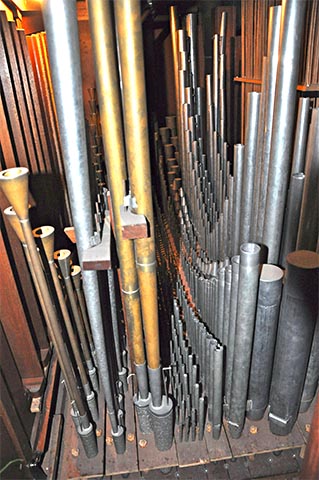 La tuyauterie du Brustwerk.De gauche
                    (jalousies, donc façade) à droite : le Hautbois (laiton) avec ses
                    opercules,le Chalumeau, la Douçaine (laiton), la Cymbale, le Sifflet et la
                    Doublette,la Flûte à fuseau (dont les double-cônes sont très marqués mais
                    dont les basses sont bouchées,l'Unda-maris et le Gemshorn et ses tuyaux
                    coniques.
