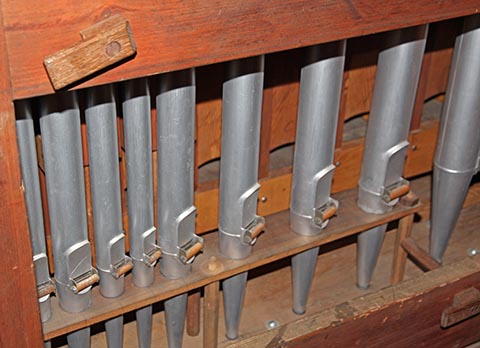 Voici, logés dans leur boîte expressive tout au fond de l'orgue, des tuyaux de la Soubasse (au fond, le nom du jeu est inscrit au crayon au-dessus des bouches) et du Violoncelle 8' de pédale (avec ses freins harmoniques constitués de rouleaux en bois).