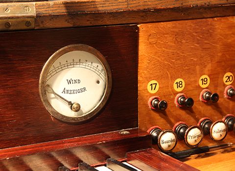 Détail de la console. Avant la restauration de 1986, le cadran indicateur de niveau du réservoir était remplacé par une photo en médaillon d'Albert Schweitzer (apparemment extraite de celle qui est affichée sur le buffet, voir plus loin). On peut distinguer, à droite (au-dessus de 17, 18, 19), les 6 trous rebouchés correspondant aux 3 tirants et à leur picot de combinaison libre. Ces tirants avaient été ajoutés en 1935.