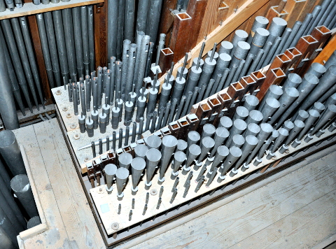 La tuyauterie du grand-orgue, à l'étage.
Derrière la façade centrale (visible en haut à gauche) se trouve
le sommier supérieur, des "grands jeux" du grand-orgue.
Il y a 8 chapes : de bas (accès) en haut (façade) :
le Clairon (dont les 14 notes aiguës sont à bouche, et 6 tuyaux harmoniques),
la Trompette (dont les 8 tuyaux aigus sont harmoniques),
la Flûte 8', toute en bois et sans faux-sommier,
la Gambe 8', le Bourdon 16' (dont les dessus sont à cheminées),
le Principal 16', le Principal 8' et le Principal 4'.