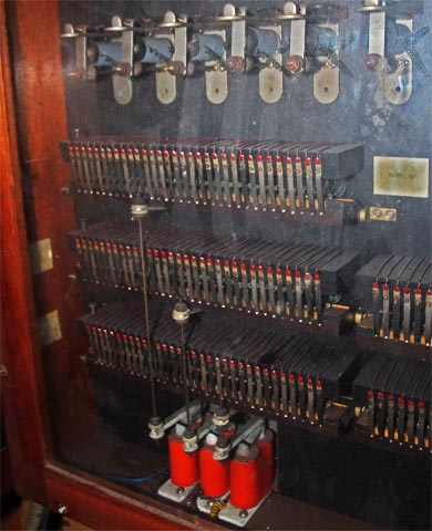 Au centre de cette armoire électrique vitrée (sous les
            6 relais bleus),les 32 contacts des notes de la grande Flûte 16' de pédale.